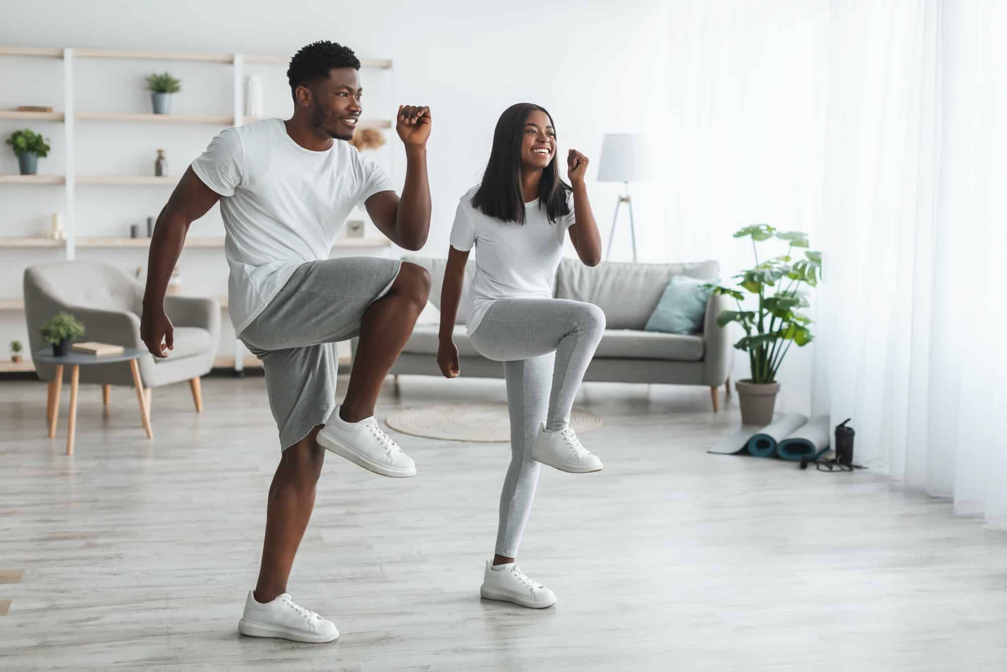 Young black couple doing high knee exercise